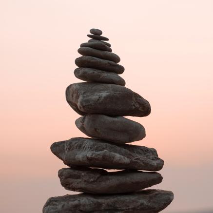 A pile of stones sits balanced atop one another on the beach.