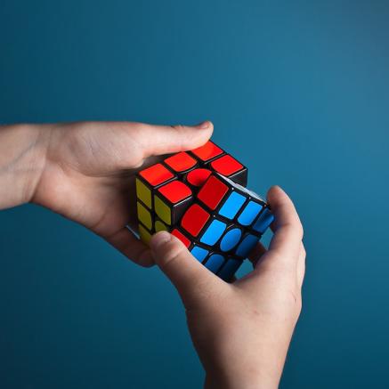 Hands holding and solving a rubik's cube 