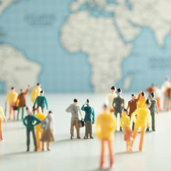 Small figurines of people in front of a world map