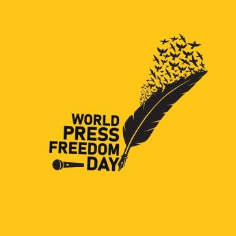 Yellow background, black text that says "World Press Freedom Day" a black quill that turns into black birds and a black mic 