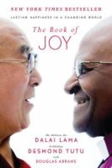 Book Cover for the Book of Joy, featuring a close up photo of the Dalai Lama and Archbishop Desmond Tutu in profile, smiling at each other