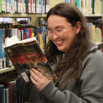 Educator & School Services Librarian Diana Price, reads a book from one of her favorite series.