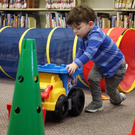 A young patron plays with toys available during the library's Stay & Play event
