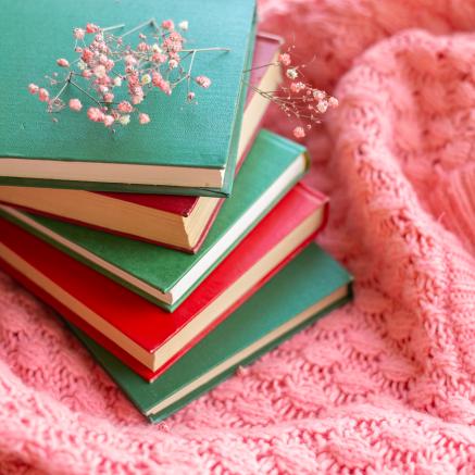 Stacked books with flowers and knit fabric