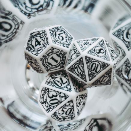 Dungeons and Dragons dice set pictured with black and white dice. The edges of the picture are slightly rounded and blurred.