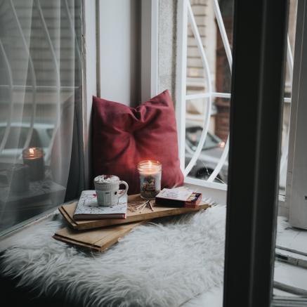tea, book, candle, pillows on window seat