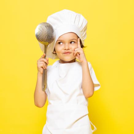 front-view-kid-chef-holding-big-spoon-yellow-wall