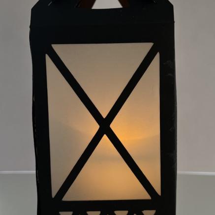 black paper lantern with a battery operated tea light shining through