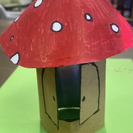 mushroom crafted from paper with a opening in the front like a little door for a place to put a tealight 