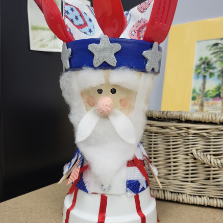 An red, white, and blue Uncle Sam-style utensil holder craft.