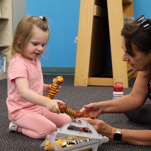 A child and their caregiver play with items in the Youth Services area at the Cinnaminson Library.