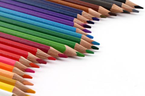 Colored pencils arranged in a curved line.