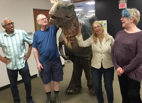 The Friends pose with a T-Rex at the library.