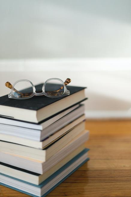 Pile of books with a pair of glasses on top