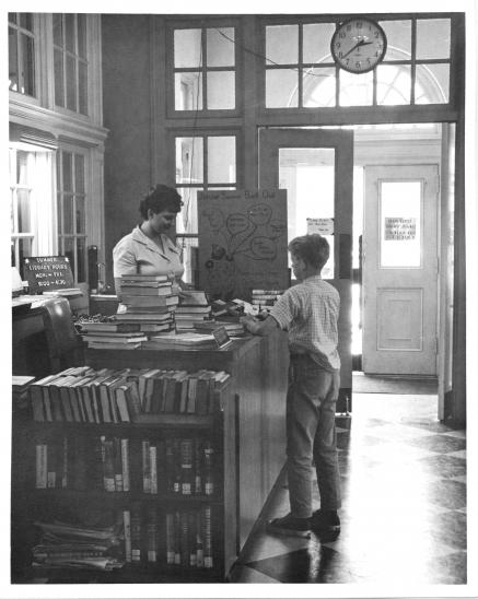 A student checks out books at the County Library, 1950s