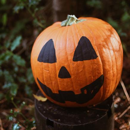 A pumpkin is painted to look like a jack-o-lantern.