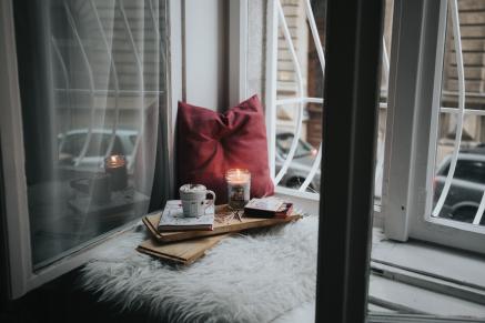 tea, book, candle, pillows on window seat