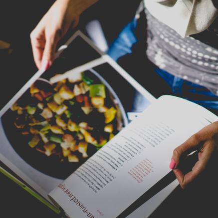 A person holds open a cookbook.