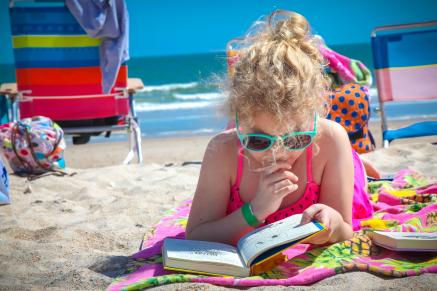 Girl reading on a beach.