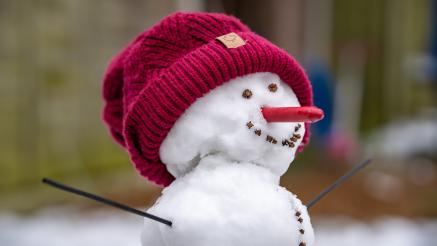 Snowman with a red knit hat.
