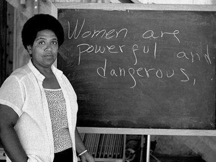 Audre Lorde with a chalkboard that says: Women are powerful and dangerous