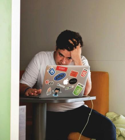 Guy stressed looking at his macbook