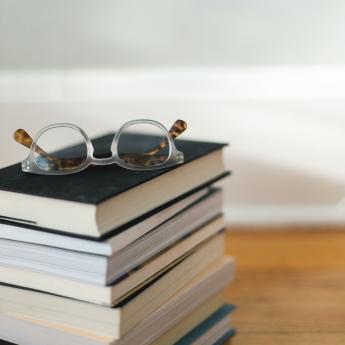 Pile of books with a pair of glasses on top