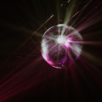 A disco ball reflects light back on the dance floor.