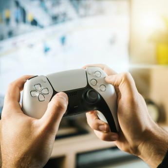 A person holds a video game controller while playing a game