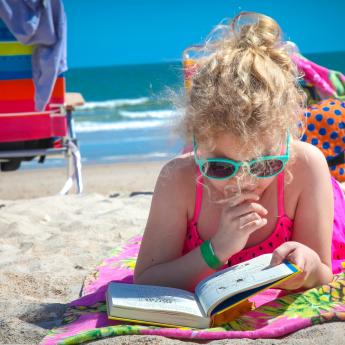 Girl reading on a beach.